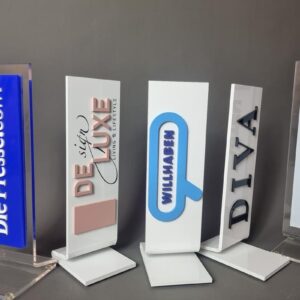 Tischaufsteller mit Markenlogos aus Acrylglas in Reihe nebeneinander