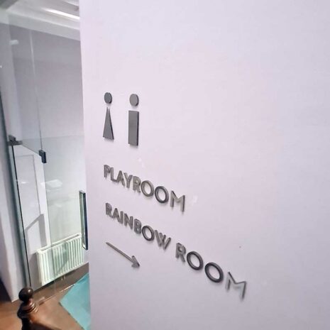 Edelstahl-Einzelbuchstaben mit Playroom- und Rainbow-Room-Beschriftung im Pilates Studio