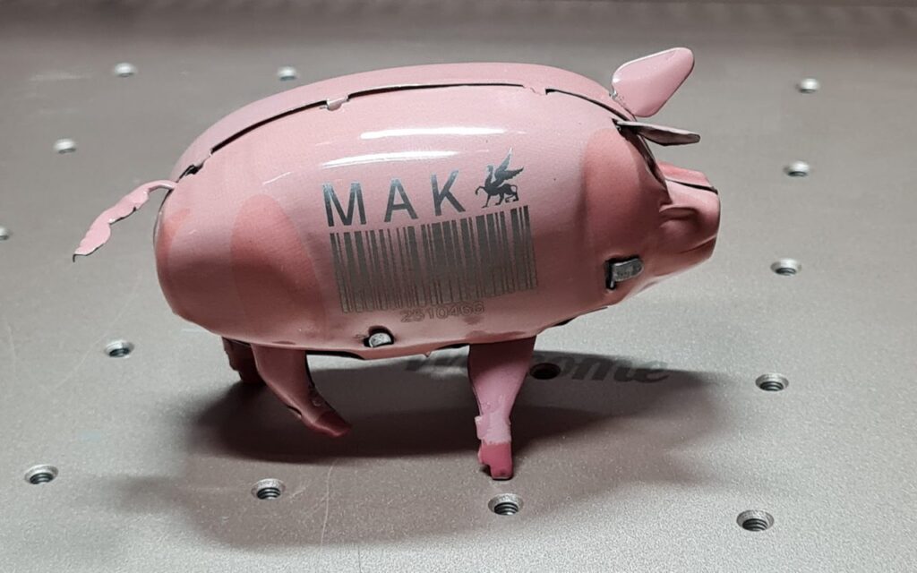 Lasergraviertes rosa Metall-Schwein mit MAK-Logo und Barcode, Laserschnitt Wien